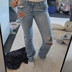 Ljusblå bootcut jeans med slitningar - Säljer ett par ljusblå bootcut jeans Från gina som jag gjort flera hål i. Finns ett hål där bak så man ser igenom lite same några fläckar men inte så tydliga! 