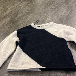 Svartvit stickad tröja Gina Tricot - Cool stickad tröja från Gina Tricot i svart och vitt med diagonal färgblock-design. Tröjan har rund halsringning och långa ärmar. Perfekt för dig som gillar en stilren men ändå unik look. Har inte använt på jättelänge då den förstördes i tvätten (blev mindre)