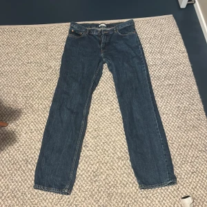 Blåa straight jeans från Perfect Jeans - Säljer ett par klassiska blå jeans från Perfect Jeans i storlek 38. De har rak passform, fem fickor och snygga kontrastsömmar. Jeansen är tillverkade i ett tåligt denimtyg och har en tidlös look som funkar till allt. De är lågmidjade.