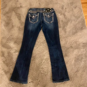 Miss Me blå bootcut jeans med paljettdetaljer - Midjemått: 38cm Innerbenslängd: 75cm Jätte fint skick däremot saknas en knapp på märkeslappen då det ska vara 4 men är 3. 