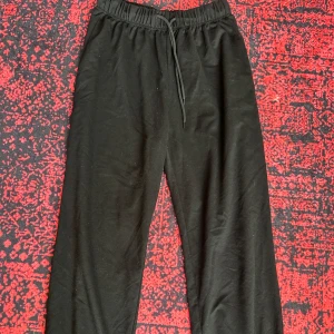 Svarta mjukisbyxor  - Svarta mjukisbyxor med elastisk midja och snörning framtill. Byxorna har ribbade muddar vid bensluten och är tillverkade i mjukt bomullsmaterial. Perfekta för chill eller häng med kompisar.