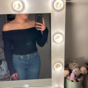 Svart offshoulder ribbad topp strl XS - Säljer en svart ribbad offshoulder topp med långa ärmar från Gina Tricot i storlek xs. Toppen har en bred kant över axlarna och är figurnära i modellen. Materialet är en mix av viskos, polyester och polyamid vilket gör den mjuk och stretchig. Perfekt för dig som gillar en stilren och trendig look.