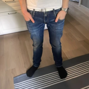Blå Replay Anbass jeans herr - Säljer ett par blå Replay Anbass jeans med snyggt slitna detaljer och klassiska bakfickor. Jeansen har en smal passform och normal midja, tillverkade i mjukt denimtyg. Perfekta för dig som gillar en modern och stilren look. St w30 och L32