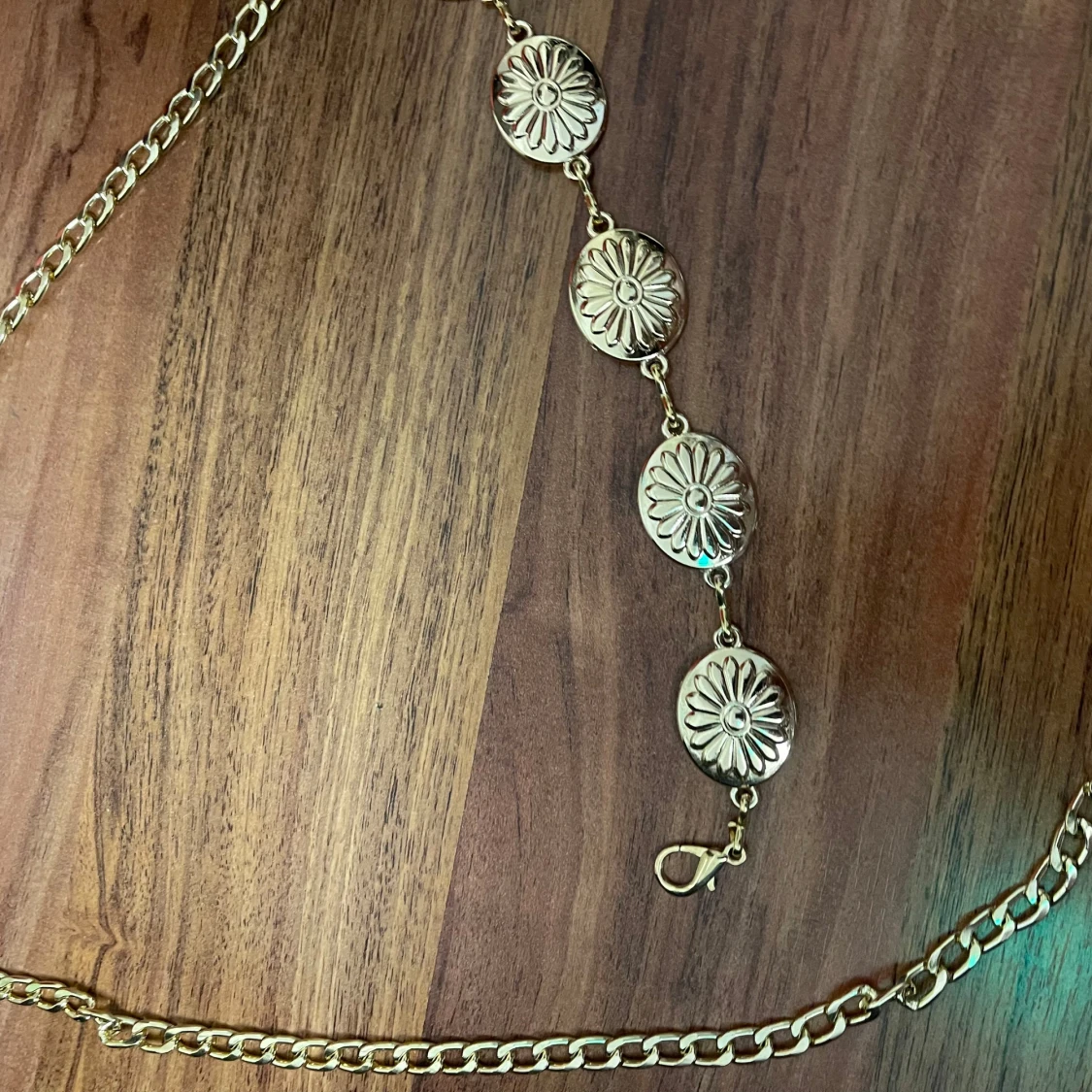 Guldfärgat kedjebälte med blommor