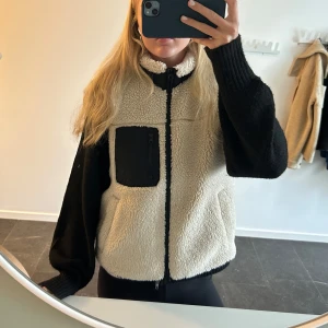 Teddyväst - Mysig beige teddyväst med svarta detaljer. 