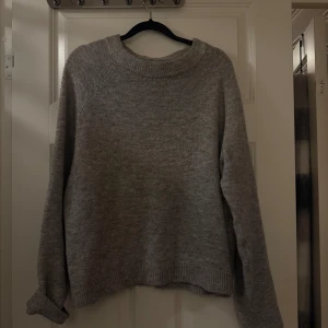 Grå stickad tröja med rund hals - Mysig grå stickad tröja med rund halsringning och ribbade muddar vid ärmslut och nederkant. Är en xl men är mer som en m 