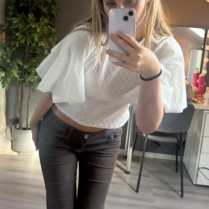 Vit blus med voluminösa ärmar  - Superfin vit blus från bubbleroom med rund halsringning och stora voluminösa korta ärmar. Blusen har ett diskret strukturmönster i tyget och är lätt croppad. Perfekt både till fest och vardags! Aldrig använd, lappen är kvar.