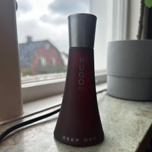 Hugo Boss Deep Red parfym - Stilren parfym från Hugo Boss med namnet Deep Red. Den är väldigt sparsamt använd. Man kan se hur mycket som finns i flaskan om man kollar noga på bilden. 