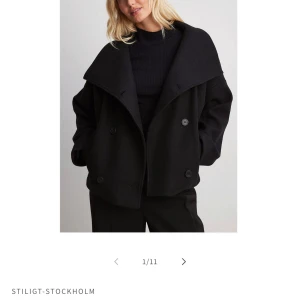 Svart skepparkavaj från Stiligt Stockholm - Snygg svart skepparkavaj från Stiligt Stockholm med bred krage och dubbelknäppning. Jackan har en boxig, lite oversized passform och är tillverkad i ett ullblandat material. Perfekt för dig som vill ha en stilren och trendig look. Helt oanvänd!