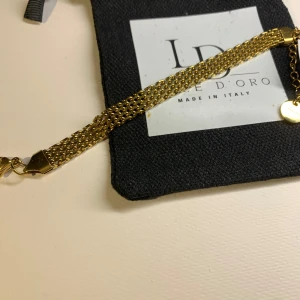 Guldarmband från Luce D'Oro - Snyggt armband i guldton från Luce D'Oro, tillverkat i Italien. Armbandet har flera kedjor som ger en bred och elegant look, och är gjort i rostfritt stål. Detaljer med små runda berlocker vid låset. Perfekt accessoar för att lyfta din outfit.