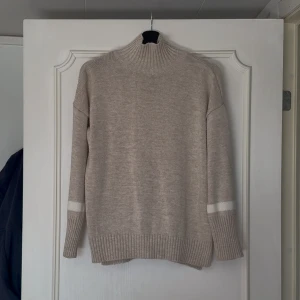 Beige stickad polotröja - Superfin beige stickad polo med vita detaljer ifrån NA-KD. Fint skick. Normal i storleken. 