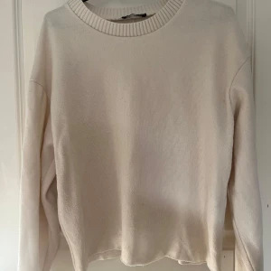 Beige stickad tröja med rund hals - En stilren beige stickad tröja med rund halsringning och långa ärmar. Tröjan har en ribbad kant vid halsen och är i en mjuk, skön kvalitet. Använd relativt mycket och lite nopprig men inget jag tycker att man ser när man använder den, därav priset💕