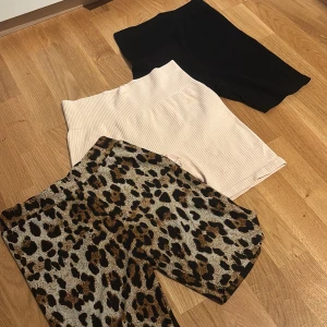  cykelshorts i olika färger och mönster - Säljer tre par cykelshorts/träningsorts: ett par med leopardmönster i svart och brunt, ett par ribbade ljusrosa och ett par ribbade svarta. Alla har hög midja och stretchigt material, perfekta för sommaren eller gymmet! 20kr/st
