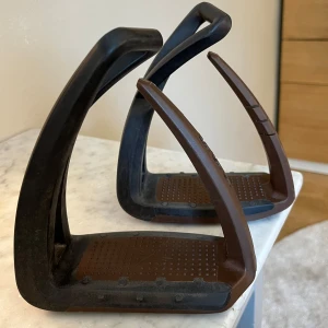 Freejump Soft’up lite stigbyglar - Säljer ett par bruna Freejump Soft'Up lite stigbyglar. Använda men i gott skick, endast mindre repor och normalt slitage. Piggarna har slitits ner något men inget som märks, se sista bild. Vet ej storlek men max 60 kg kroppsvikt. Kostar 2150 i nyskick. Säljes för 700 eller bud 