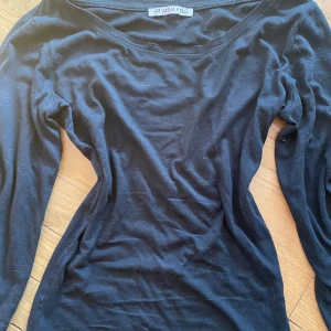 Svart långärmad topp från Anna Field - En svart långärmad topp från Anna Field i mjuk bomull. Modellen är figurnära med rund halsringning och klassisk stil. Perfekt att matcha med jeans eller kjol för en clean look. Sjölv sytt in den för en tajtpassform, xxs