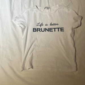 Life is better brunette tröja från subdued  - Vit t-shirt från Subdued med svart texttryck 'Life is better BRUNETTE' på bröstet. Säljer då den blivit för liten, bra skick endast använd en gång men har en liten pläck längst ner på tröjan. Något som säckert går bort. Skulle säga att den är i storlek xxs/xs nypris 456 kr 