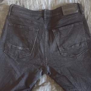 Svarta jeansbyxor regular fit - Svarta jeansbyxor från Froggland i regular fit med klassisk femficksdesign och silverfärgade nitar. Byxorna har rak passform och normal midja, perfekta för en clean och stilren look.