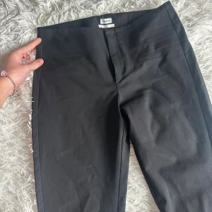 Svarta kostymbyxor från Filippa K - Svarta kostymbyxor från Filippa K i klassisk rak modell. Byxorna har en stilren design med diskret bakficka och är tillverkade i ett mjukt tyg som känns bekvämt. Perfekta för en clean och snygg look.