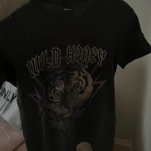 Svart t-shirt Wild Honey Gina Tricot - Vintage intryck på denna tröja från Gina Tricot med fränt tryck på framsidan