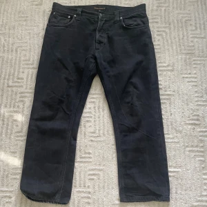 Svarta Nudie Jeans - Säljer nu dessa asfeta straight fit nudies i modellen Hank Rey! Färgen är dry black och dom har en asskön fit! Storlek 36/32 och asbra skick, inga märkbara defekter! Har du fler frågor eller funderingar? Tveka inte på att skriva!