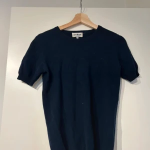 Mörkblå t-shirt från Soft Goat - En stilren mörkblå t-shirt från Soft Goat i mjukt material. T-shirten har rund halsringning och korta ärmar, perfekt för en clean och enkel look. Passar dig som gillar klassiska basplagg med en modern touch.