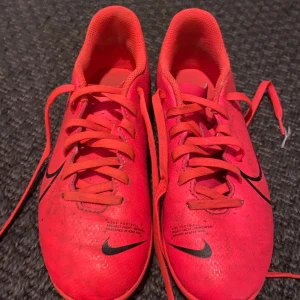 Nike Mercurial fotbollsskor neonröda - Säljer ett par Nike Mercurial fotbollsskor i en riktigt snygg neonröd färg med svarta detaljer och Nike-logga på sidan. Kontakta innan köp.
