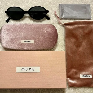 Svarta runda solglasögon Miu Miu - Snygga svarta solglasögon från Miu Miu med rund form. Kommer med originalask, fodral i rosa sammet och putsduk. I nyskick!