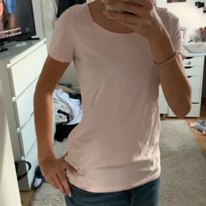 Ljusrosa basic t-shirt i bomull - En enkel och fräsch ljusrosa t-shirt med rund hals och korta ärmar. Modellen är klassisk och sitter normalt på kroppen. Perfekt för dig som gillar en clean och soft look. Materialet är mjukt och skönt bomull.