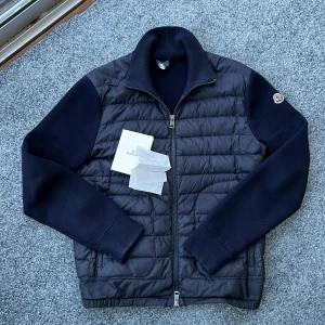 Moncler cardigan  - Säljer nu denna extremt feta moncler cardigan! Självklart äkta! Äktehetsbevis: kvitto och kort! Size : S! Passar perfekt för dig mellan 170-180cm! Skick: 9/10 lite litet slitage på armarns men syns ej vid användning! Nypris: 10000kr! Mitt pris: 4500kr! Hör av dig vid minsta fundering 🤩