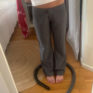 Gråa vida kostymbyxor - Snygga grå kostymbyxor med rak och vid passform. Byxorna har hög midja och är tillverkade i ett mjukt material som ger en clean och stilren look. Perfekta för dig som gillar en chill men ändå dressad vibe.