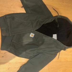 Grön Carhartt arbetsjacka med huva - Mörkgrön arbetsjacka från Carhartt 💫🌏                  Perfekt för höst eller vinter 🍂❄️                             Tungt och hållbart Kanvas material🧨💫                Quiltad insida med fodrad luva⚜️😁                       Skriv vid funderingar över pris eller annat 👊        Fler bilder kan skickas om så önskas📸🤝