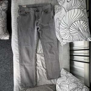 Grå Levi's 501 jeans straight fit - Snygga grå Levi's 501 jeans i straight fit med klassisk femficksdesign och knappar i kopparfärg. Använda 2-3 gånger nästan ny köpta.