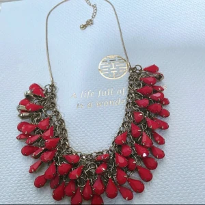 Statementhalsband  röd - Snyggt statementhalsband med droppformade röda hängen i metallkedja. Halsbandet har justerbar kedja. Perfekt för att lyfta din outfit med färg och stil.