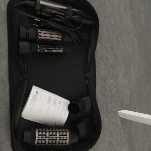 Remington varmluftsborste set - Komplett Remington varmluftsborste med flera utbytbara borsthuvuden och tillbehör i originalväska. Perfekt för styling och volym. Ser ut att vara i mycket gott skick, inga synliga defekter eller slitage. Manual medföljer.