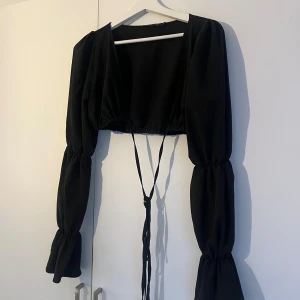 Topp med knytning - Svart topp med knyt från Nelly i stl Xs