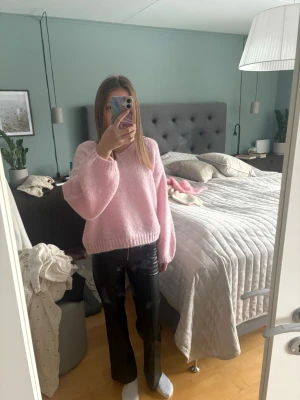 Svarta bootcut skinnbyxamed dragkedja - Säljer ett par svarta skinnbyxor med bootcut-modell och dragkedja framtill. Byxa  har en glansig finish och sitter snyggt i midjan. Perfekta för dig som vill ha en trendig och edgy look.