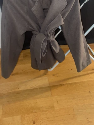 Brun kappa med bälte och slag - Jätte fin kappa från Gina tricot knappt använd .