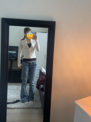 Beige/vit croppad långärmad topp - Trendig beige/vit croppad topp med långa ärmar. Toppen har en figurnära passform och dragkedja framtill. Har endast använt 2 gånger och är så gott som ny💕🫰🏼