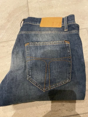 Blå tiger of Sweden jeans  - Snygga blå jeans med klassisk femficksdesign och kontrastsömmar. Jeansen har en rak passform och en läderpatch bak i midjan. Perfekta till en avslappnad stil och tillverkade i slitstarkt denimtyg.