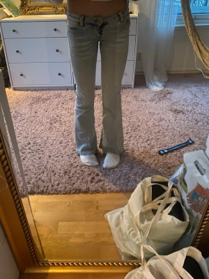 Bootcut jeans/jasnoniebieskie dżinsy - Säljer ett par ljusblå bootcut jeans med låg midja. Jeansen har klassisk femficksdesign och är tillverkade i mjukt denimtyg. Snygg passform som sitter tajt upptill och släpper ut vid bensluten för en retrovibe.