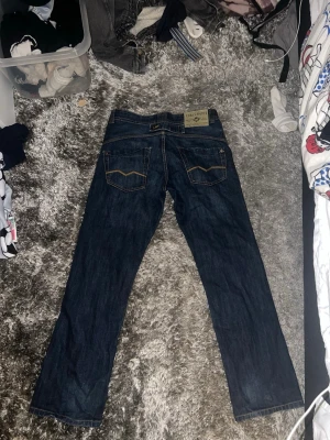 Levi's 501 mörkblå jeans straight fit - Mörkblå Levi's 501 jeans med klassisk straight fit och femficksmodell. Jeansen har kontrastsömmar och en ikonisk patch bak i midjan. Tillverkade i slitstarkt denimtyg som ger en tidlös look.