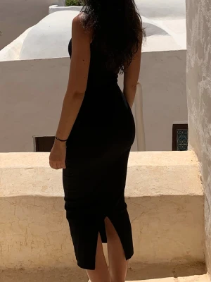 Svart långklänning med slits bak - Säljer en svart långklänning i figurnära modell. Klänningen är i bomull storlek XS från bikbok