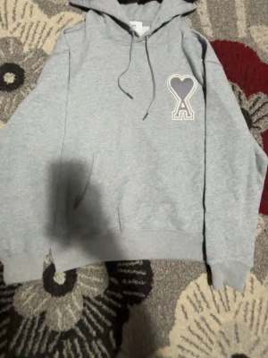 Grå hoodie från Ami Paris med hjärtdetalj - Snygg grå hoodie från Ami Paris, aldrig använda seriösa köpte skriv, S men passar perfekt som M