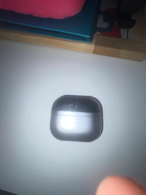 Svarta Samsung Galaxy Buds i etui - Snygga svarta Samsung Galaxy Buds med laddningsetui. Hörlurarna har en stilren och kompakt design med mattsvart finish och rundade former. Perfekta för trådlös musik och samtal, smidiga att ta med överallt.