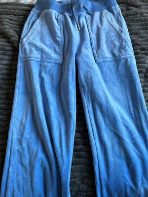 Blå mjukisbyxor från Juicy Couture XXS - Blå byxor och tröja från Juicy Couture. Använt fåtal gånger så är i nyskick, inga skavanker. Byxorna är i storlek xxs och tröjan i storlek xs. Kan säljas tillsammans eller enskilt. 1500kr tillsammans eller 800kr tröja/byxor.