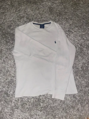 Vit långärmad tröja från Polo Ralph Lauren - Klassisk vit långärmad tröja från Polo Ralph Lauren med logga broderad på bröstet. Fräsch och bra vit i färgen. 