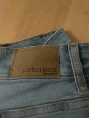 Ljusblå Perfect Jeans från Gina Tricot - Säljer ett par ljusblå utvsängda/flare jeans från Gina Tricot, modellen heter Perfect Jeans. Klassisk femficksdesign och raka ben. Jeansen har normal passform och är tillverkade i mjukt denimtyg som sitter skönt hela dagen. 