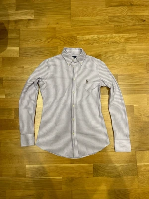 Polo Ralph Lauren Oxford Knit  - Säljer denna polo Ralph lauren Oxford knit🤩 Tröjan är i bra skick utom en defekt på kragen se på bild!!!!! Storleken är S men den sitter litet. Färgen är Lila och Vit det syns lite dåligt på bilderna. Pris 99kr