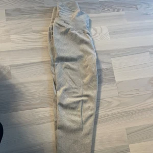 Beige ribbade leggings från Aimn - Säljer ett par snygga beige leggings från Aimn med ribbad struktur och hög midja. De är tighta och sitter riktigt bra, perfekta för gymmet eller chill hemma. Materialet är mjukt och stretchigt för maximal komfort. Diskret Aimn-logga i metall på linningen.