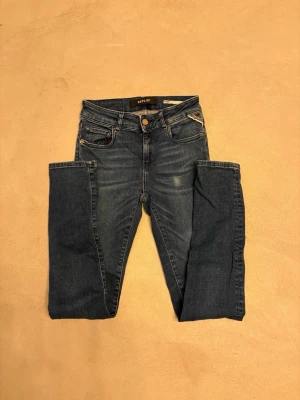 Replay slim fit jeans - Snygga blå jeans från Replay med klassisk femficksmodell och raka ben. Jeansen har normal midja och är gjorda i mjukt bomullsjeansmaterial. Perfekta för en avslappnad och stilren look. Jeansen är i storleken 24 och köptes för 1600.